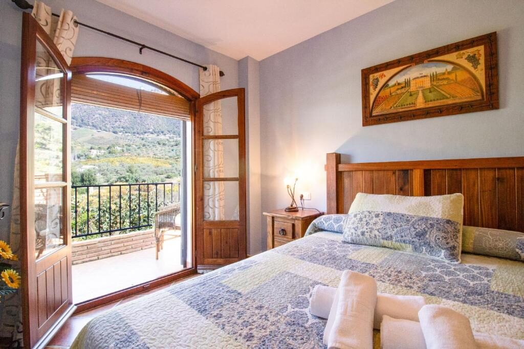 Schlafzimmer mit Zugang zum Balkon und Bergblick
