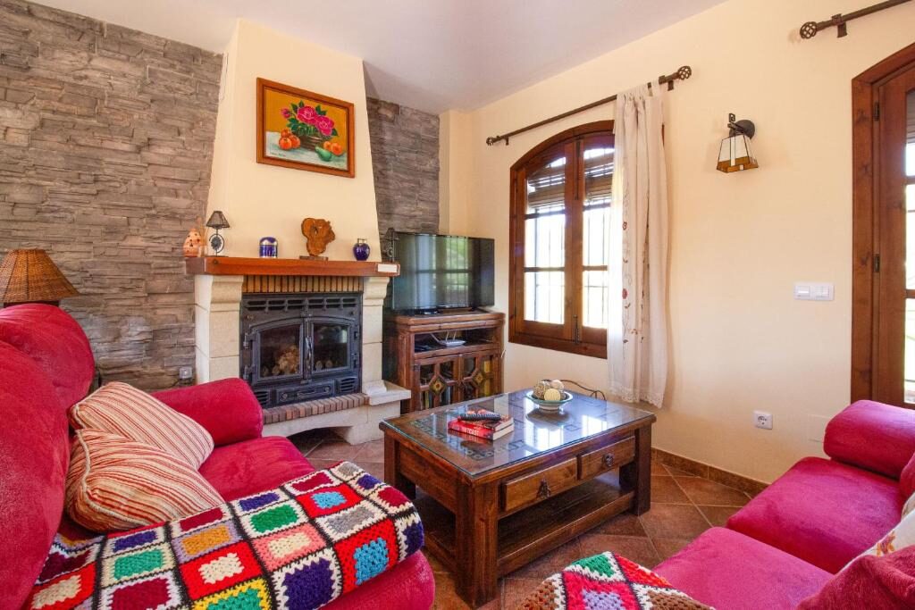 Wohnzimmer mit Kamin und roten Sofas